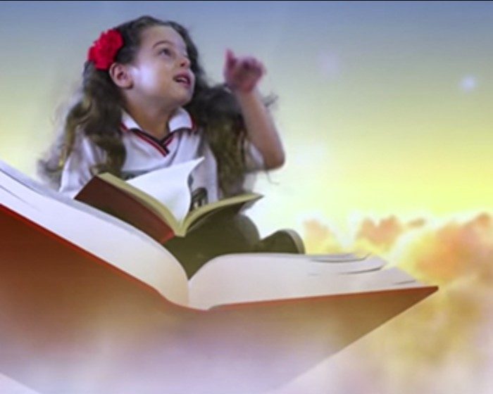 Menina com flor no cabelo sobre um livro aberto entre nuvens