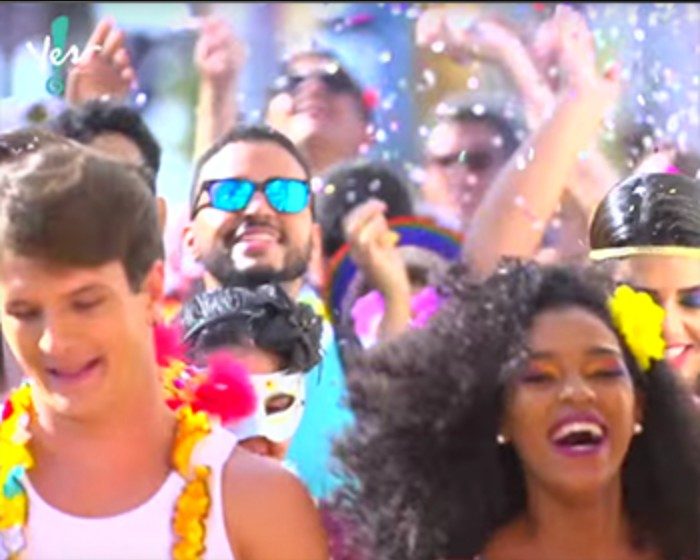 Foliões com adereços de Carnaval em cena de campanha